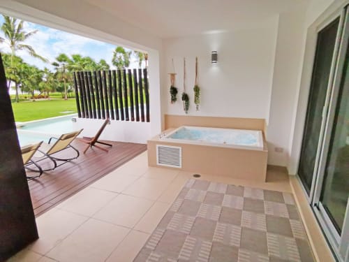 Baño de lujo en Mareazul Resort Beachfront en Playa del Carmen con bañera de hidromasaje, balcón con vista al océano y jardín tropical