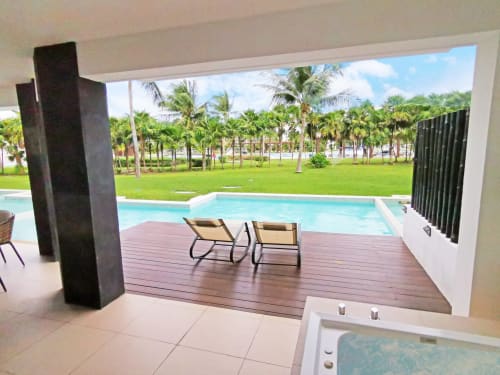 Condominio frente al mar Mareazul con patio junto a la piscina, tumbonas y jardín con vista al océano en Playa del Carmen