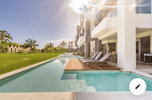 Piscina de lujo Mareazul con terraza de madera, tumbonas y jardines cuidados en Playa del Carmen