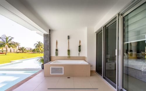 Condominio frente al mar en Mareazul Resort, Playa del Carmen con lujosa bañera spa en terraza con vistas al jardín y piscina