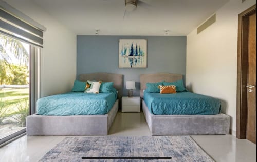 Camas gemelas con ropa de cama turquesa en un luminoso condominio frente a la playa en Mareazul Resort, Playa del Carmen, con vista al jardín
