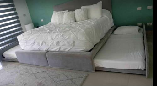 Recámara principal con cama queen, ropa de cama blanca y cama nido gemela en condominio Mareazul Playa del Carmen con pared de acento verde