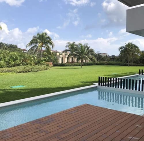 Balcón frente al mar del resort Mareazul con piscina, terraza de madera, jardín cuido y palmeras en Playa del Carmen
