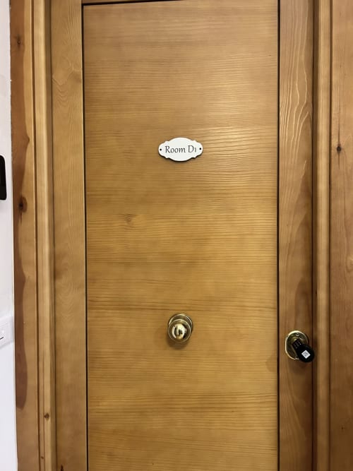 Wooden door to Room D1 at Maison Vaticana Guest House Rome with brass lock and room nameplate