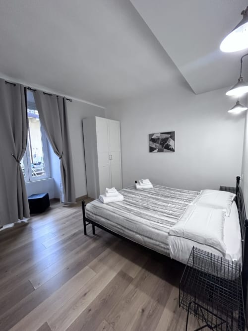 Modern bedroom suite at Maison Vaticana Rome with double bed, white wardrobe, window, and contemporary lighting