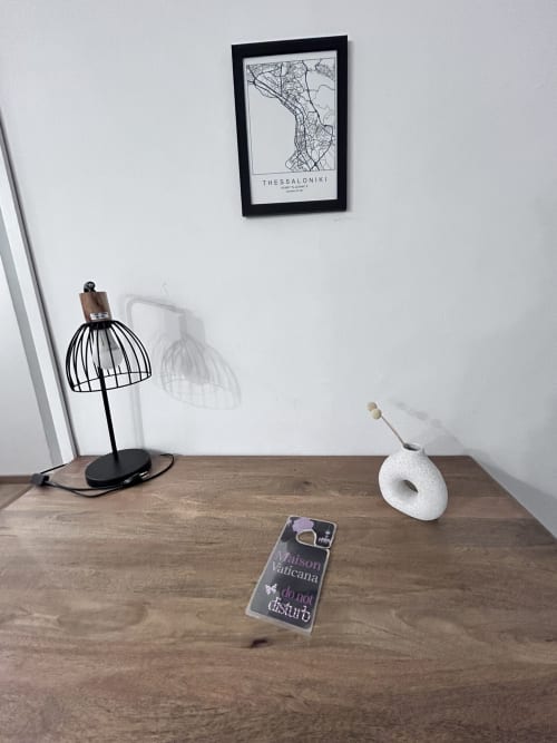 Modern desk in Maison Vaticana Rome suite with desk lamp, decorative items, and Thessaloniki map on wall