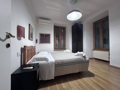 Spacious De Luxe Double Room at Maison Vaticana Guest House Rome with queen bed, wooden floors, and modern amenities