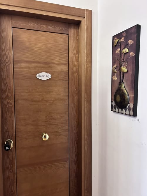 Room D3 door at Maison Vaticana Guest House Rome with decorative floral artwork on adjacent wall