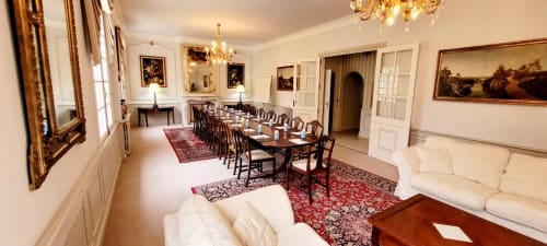 Elegant formal dining room at Domaine de Bize with long table, cream sofas, and period artwork in Mirepoix