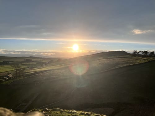 Sunrise over rolling hills near Haydon Bridge, Hexham, with golden light illuminating the countryside landscape