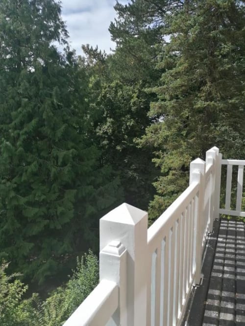 White balcony railing overlooking lush forest at Villa Eliane, Étretat deluxe room with garden view