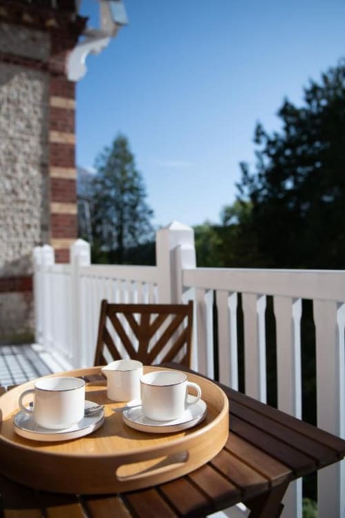 Deluxe balcony room at Villa Eliane in Étretat with coffee service, white railings, and garden views