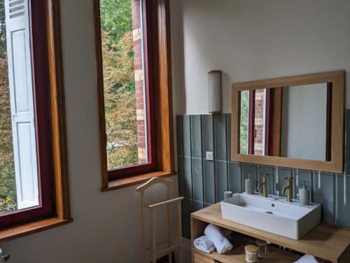 Modern bathroom with wooden vanity, white rectangular sink, mirror, and garden views at Villa Eliane, Étretat