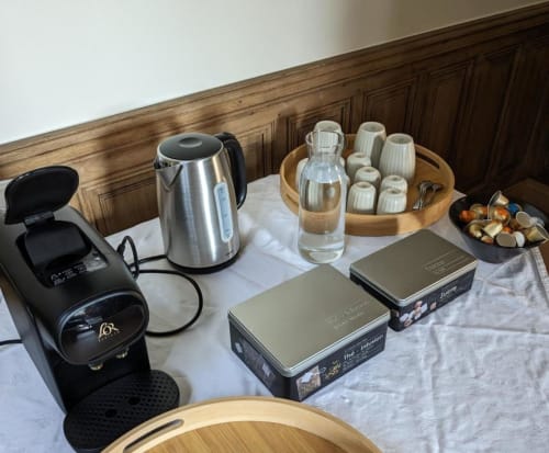 Plateau de bienvenue en chambre à Villa Eliane B&B Étretat avec bouilloire, eau, verres, cafetière et articles de toilette