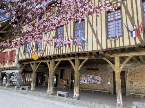 Bâtiment à colombages historique de Mirepoix avec fleurs de magnolia rose et galeries en bois