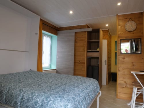 Chambre spacieuse au Sci Saviya B&B à Égletons avec accents bois, lit queen et équipements modernes