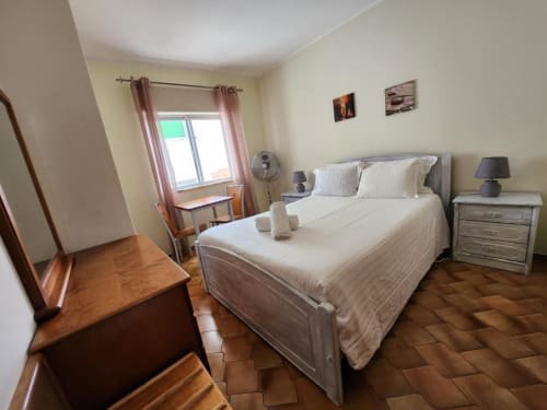 Bright bedroom at Casa do Sol Algarve in Lagos with queen bed, wooden furniture, and pink curtains