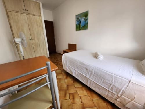 Spacious bedroom at Casa do Sol Algarve in Lagos with single bed, wooden wardrobe, and ceramic floor