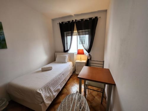 Quarto aconchegante no hotel Casa do sol Algarve em Lagos com cama de solteiro, escrivaninha e cortinas pretas