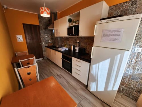 Modern kitchen with orange walls and white cabinetry at Casa do sol Algarve, Lagos Portugal