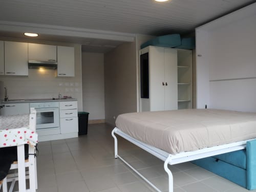 Studio à Sci Saviya Égletons avec lit, cuisine et mobilier blanc