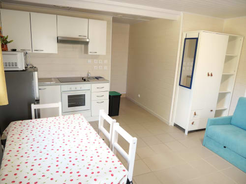 Appartement Sci Saviya à Égletons avec cuisine, table à manger, canapé turquoise et chambre