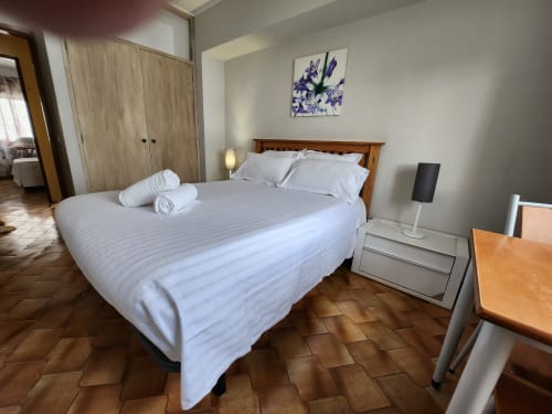 Clean double bedroom at Casa do Sol Algarve hotel in Lagos with wooden bed, white linens, and terracotta tile flooring