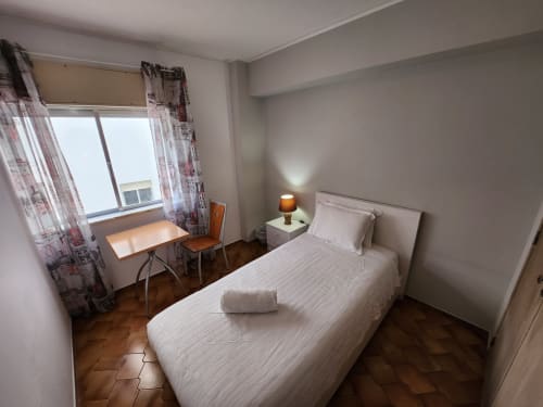Single room at Casa do Sol Algarve hotel in Lagos with bed, desk, window, and wooden flooring