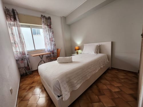 Single room at Casa do Sol Algarve in Lagos with twin beds, white linens, terracotta floor, and window with patterned