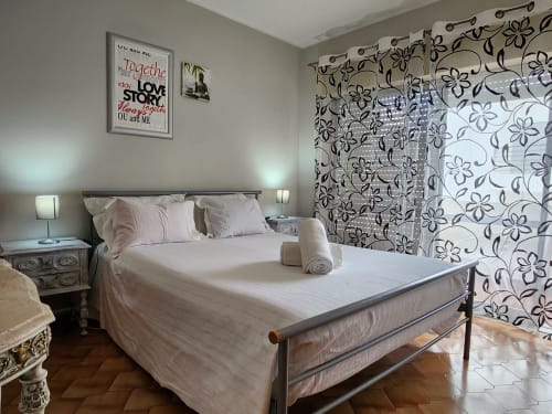 Quarto moderno em Casa do Sol Algarve em Lagos com cama queen, biombo floral e luminárias de cabeceira