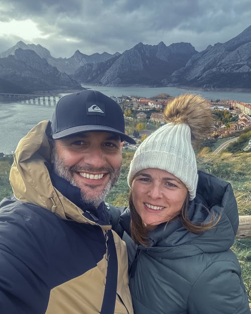 Couple smiling at scenic mountain lake overlook in Ribadesella, Spain near Esto si es vida hotel