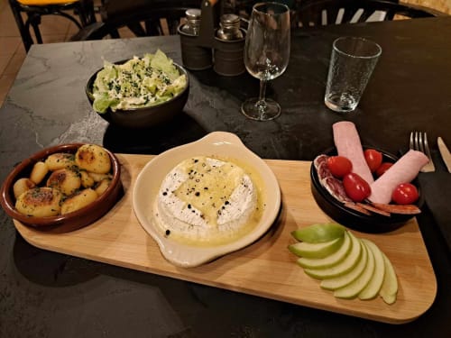 Plateau de charcuterie aux Deux Porches Verrières avec fromage, charcuterie, pommes de terre, légumes et verres de vin