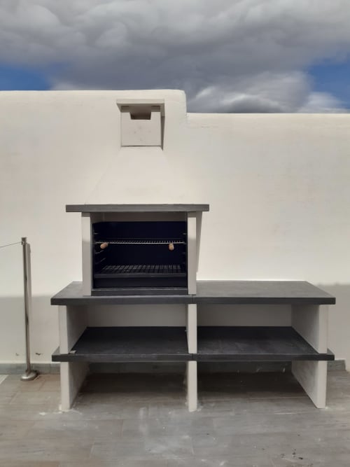 Barbecue intégré en plein air avec étagères superposées et murs en béton blanc à la Casa Rural La Perla