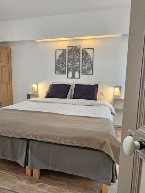 Modernes Schlafzimmer im Domaine à l'Aise mit Queensize-Bett, schwarzen Kissen, Baummotiv und Gartenblick