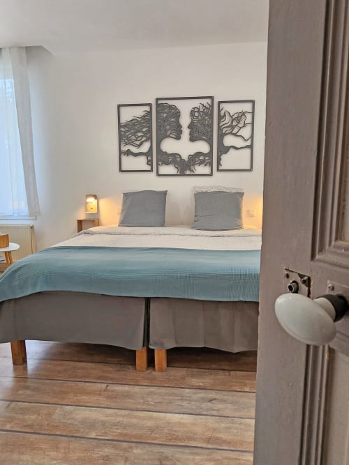 Modernes Schlafzimmer im Domaine à l'Aise mit blauem Bettwäsche, grauen Kissen, Wandkunst und warmem Licht in Saint-Pargoire