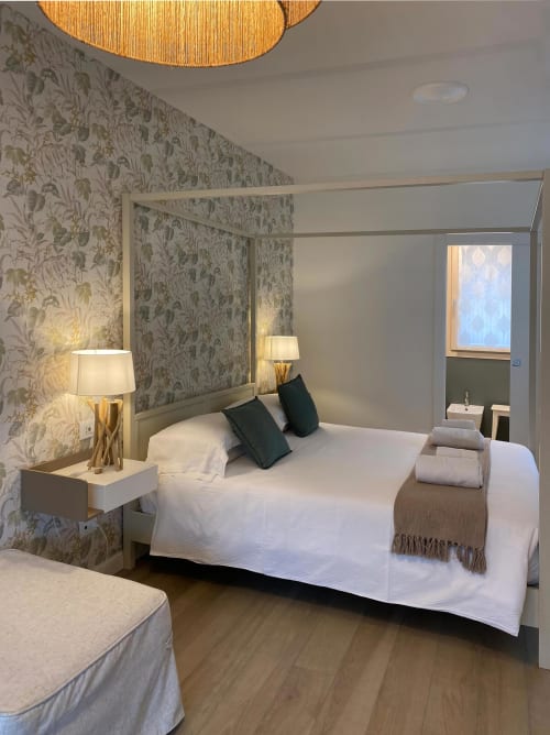 Elegant bedroom at Verdolivo B&B in Sale Marasino with canopy bed, patterned wallpaper, and modern furnishings