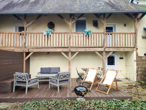 L’espace extérieur privé du Lodge avec table à manger, salon de jardin, transat et un grand parasol