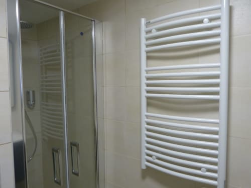 Modern bathroom at Villa Thébaïde with glass shower enclosure and white heated towel rack in Cérise room, Laudun L'Ardoise