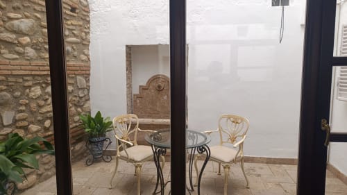 Patio Suite Comares Granada con sillas decorativas, plantas en maceta y patio de piedra