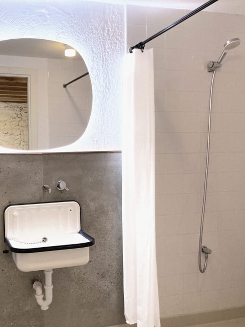 Baño moderno con lavabo mural, espejo iluminado y ducha en Casa rural MAÑARINEGI Landa apartamentuak, Gipuzkoa