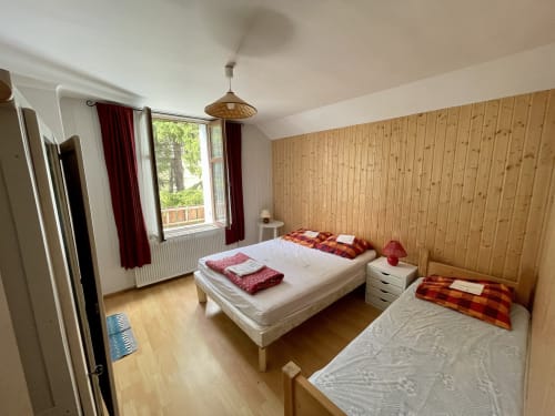 Chambre donnant sur le jardin avec un lit simple et un lit double