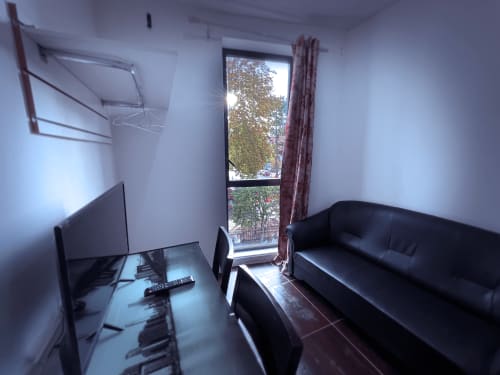 Chambre moderne à Chambre Pasteur, Montreuil : canapé noir, TV et vue sur rue