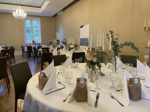 Élégante salle à manger à La Maison Verneuil à Paray-le-Monial avec nappes blanches, compositions florales et couverts raffinés