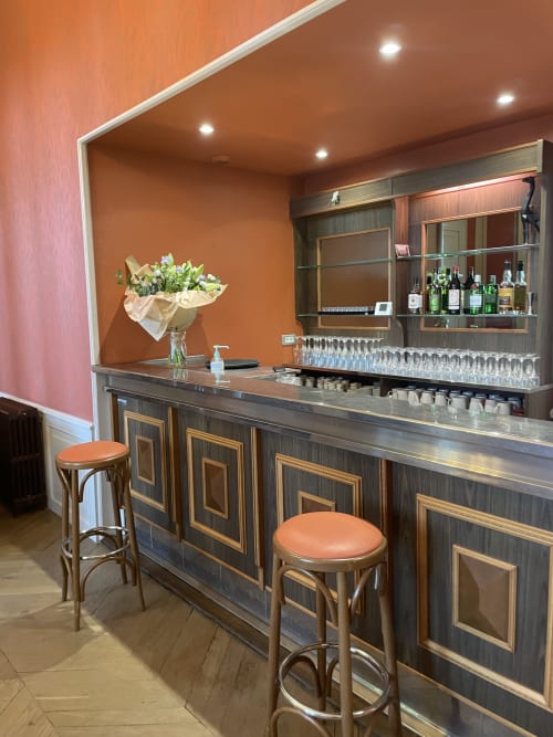 Bar élégant de l'auberge La Maison Verneuil à Paray-le-Monial avec boiseries, murs orangés et comptoir