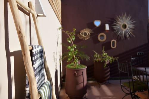 Riad Palau Marrakech patio with striped textiles, potted plants, and decorative wall art