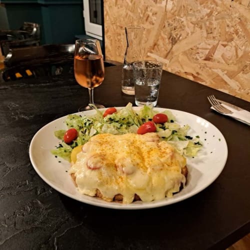 Œufs Bénédict gourmands avec fromage fondu, salade fraîche et rosé aux Deux Porches à Verrières