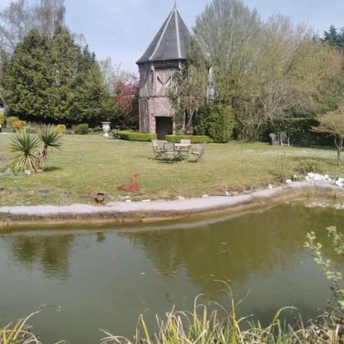 Le jardin de La Cour d'Hortense avec tour en pierre, bassin et parc aménagé à Sailly-Flibeaucourt