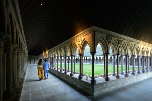 Un couple marche main dans la main dans l'abbaye du Mont Saint-Michel