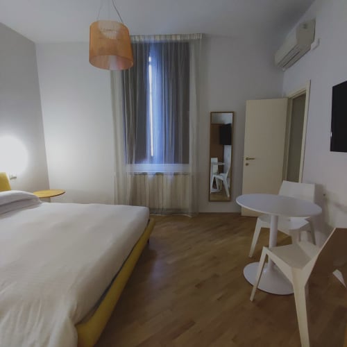 Stella CasaBono superior matrimonial room in Sulmona with queen bed, white round table, pendant lamp, and modern amenities
