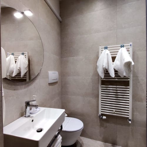 Modern bathroom in Stella CasaBono hotel with white sink, toilet, heated towel rail, and mirror in Sulmona